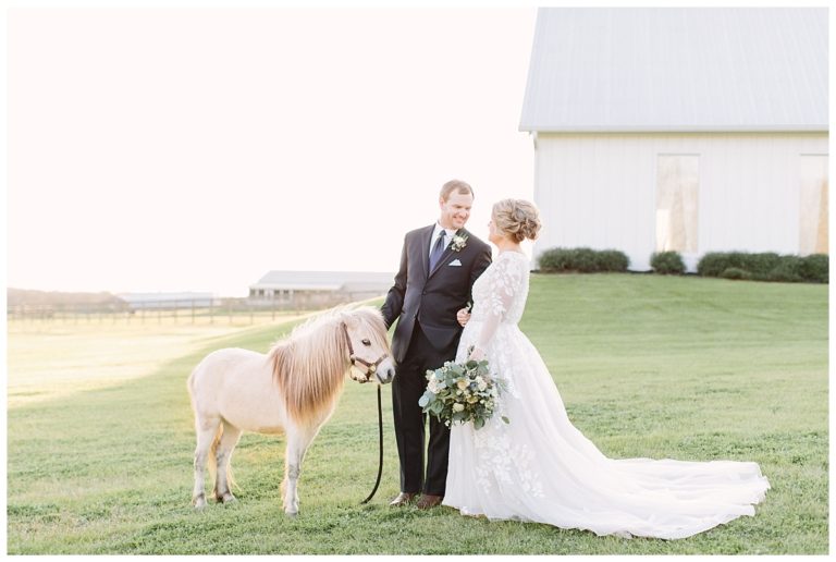 Bride and Groom by chapel with pony gazing at each other | The Farmhouse Events Real Weddings| A Little Something Blue| Kelly & Jarrod