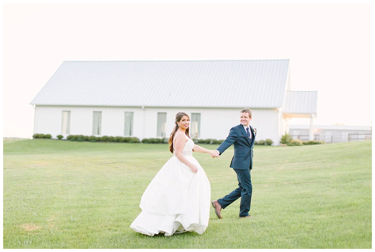 Bride and groom running though fields with chapel in background | The Farmhouse Events Real Weddings| Montgomery TX| Christina & Eric 